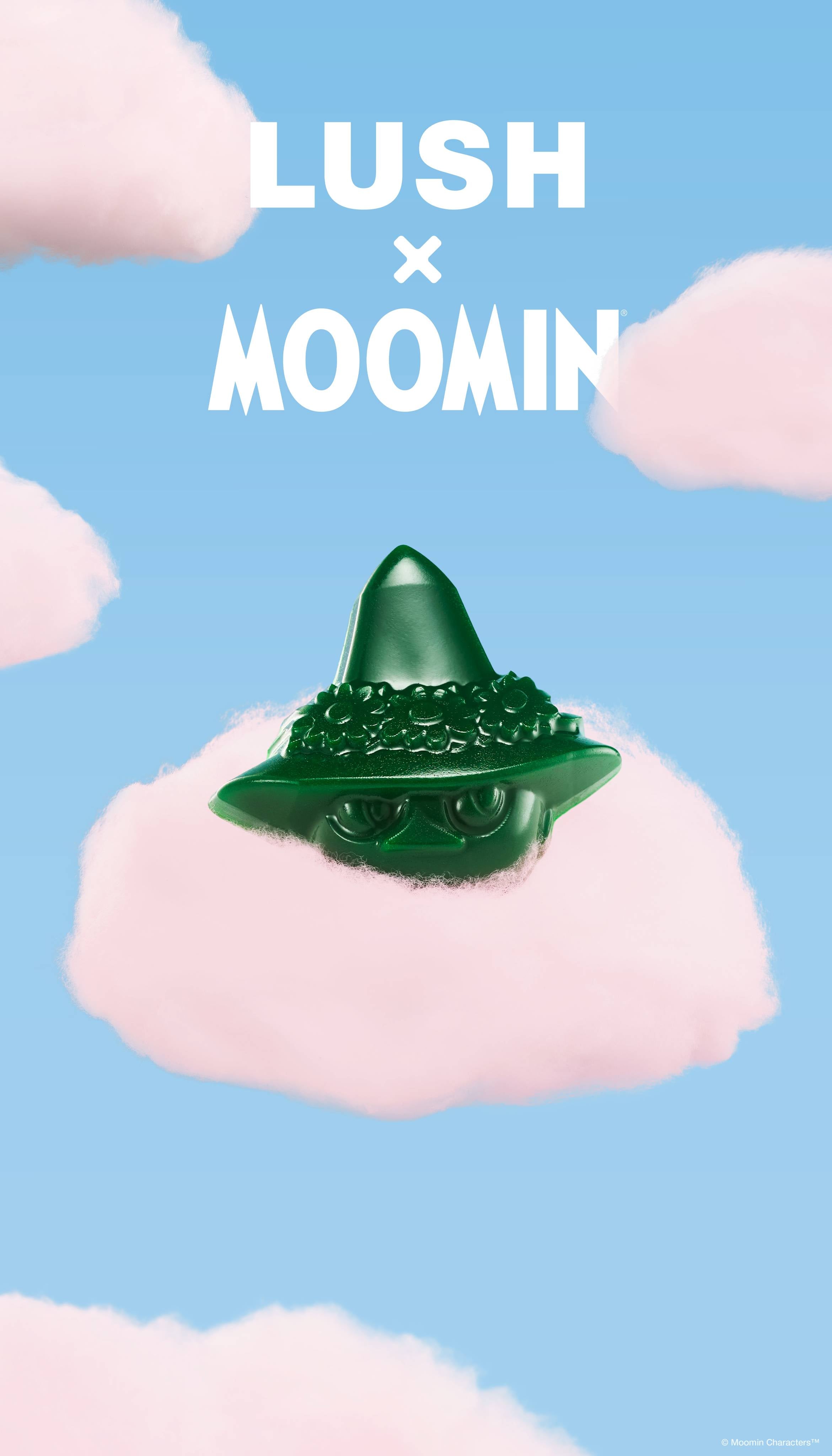A promotional graphic featuring a green Snufkin-shaped soap bar resting on a fluffy pink cloud. The sky-blue background is filled with scattered pink clouds below bold white text reading "LUSH x MOOMIN".