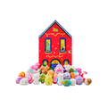 A red brick house-shaped gift box stands behind a large display of festive bath products, including a sleeping fox, a bear, a penguin, and a Christmas tree bath bomb, among many more themed products.