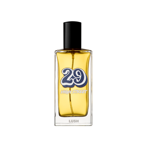 29 High Street. A rectangular glass perfume bottle containing a yellow liquid perfume, featuring a black cylindrical cap. The label shows a large, retro-style blue number '29' with 'HIGH STREET' and the 'LUSH' logo in white text.