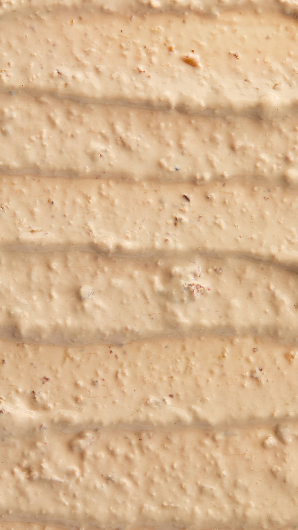 A super close-up image of the creamy, textured Bring Us Some Figgy Pudding face mask product, focusing on the consistency and flecks of finely blended dried figs throughout.