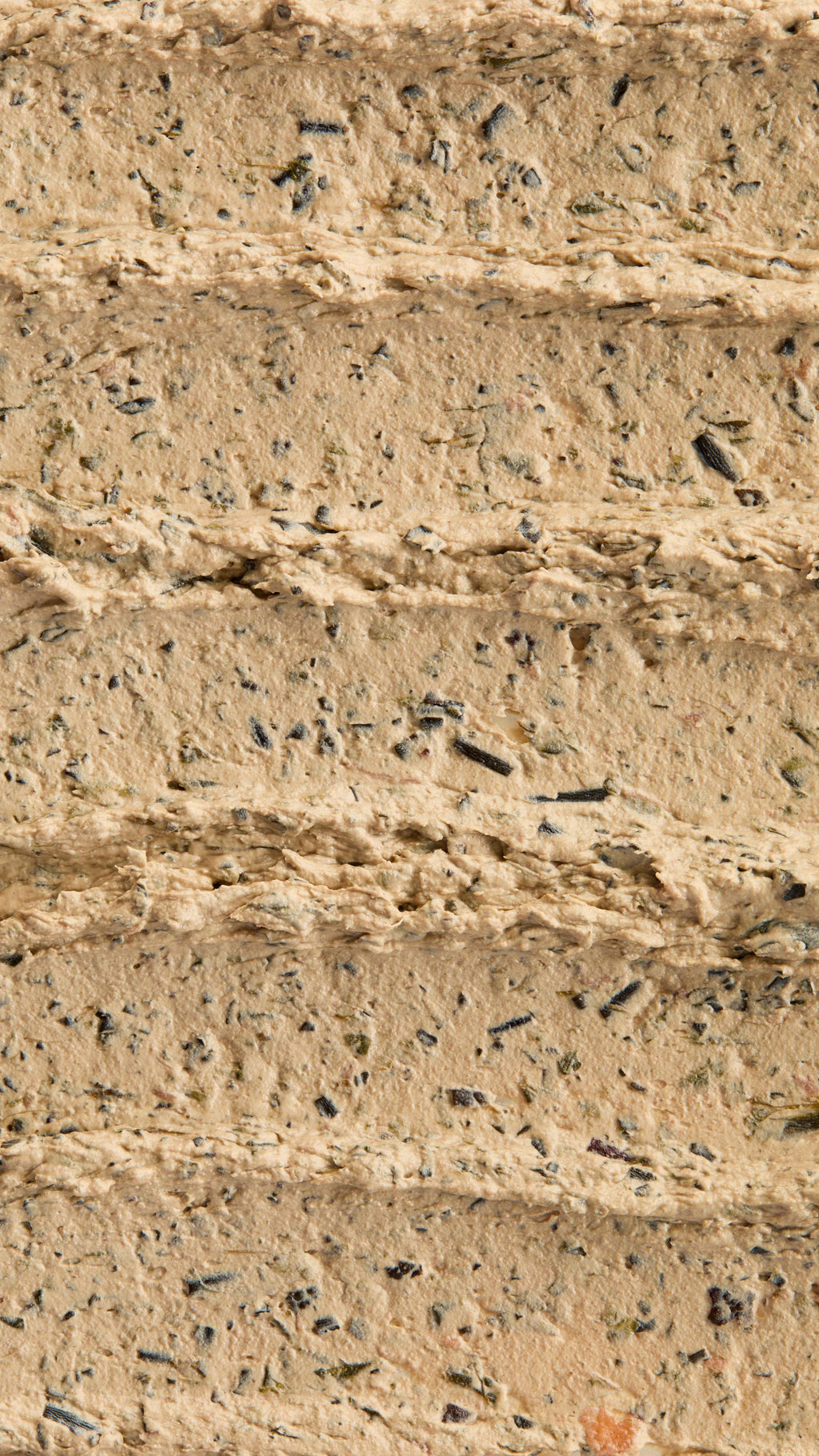 A super close-up image of the creamy, textured Mineralise Me face mask product, focusing on the thick consistency of the flecks of finely blended seaweed.