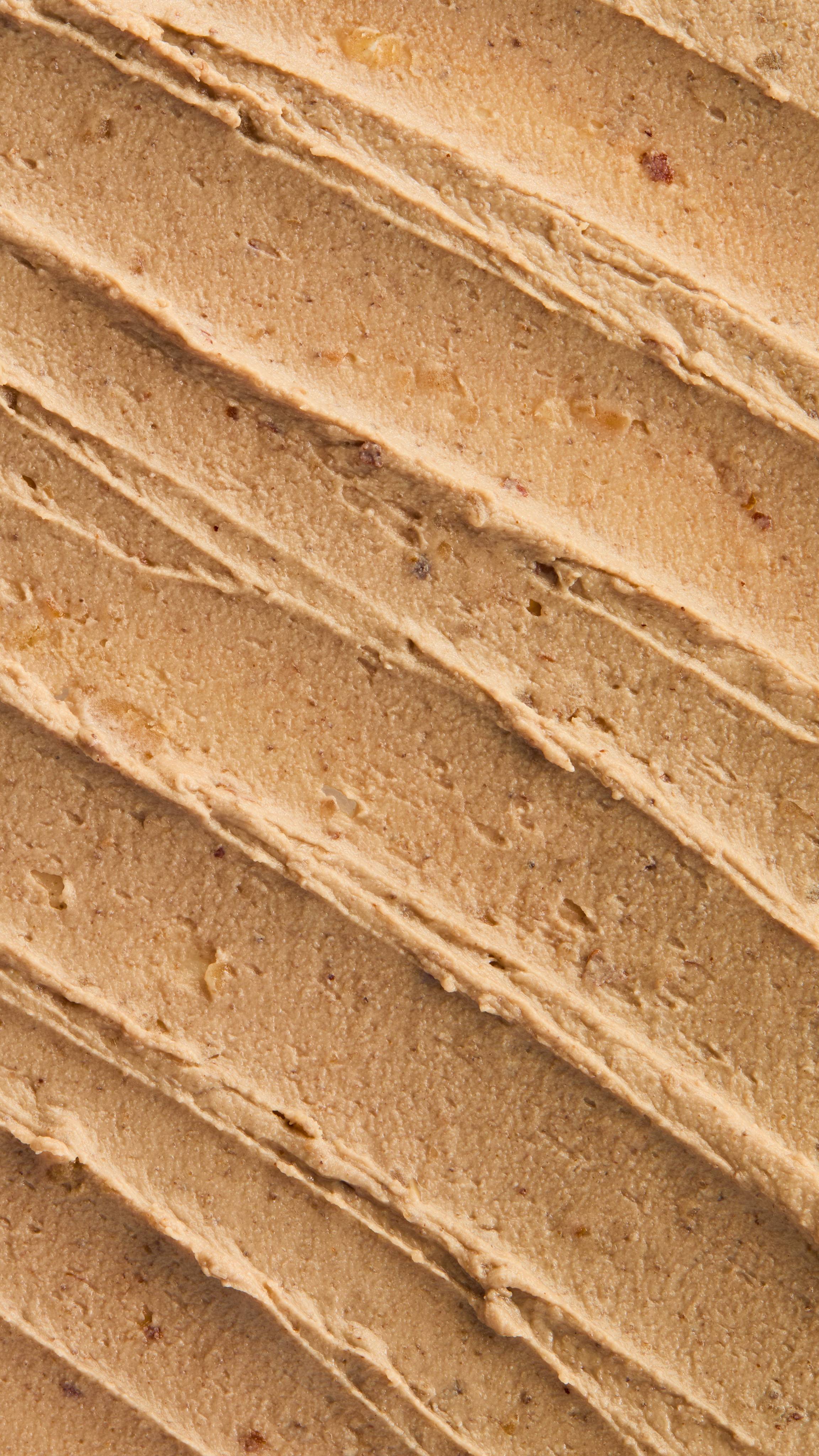 A super close-up image of the creamy, textured Nutkins face mask product, focusing on the thick consistency of the flecks of finely blended nuts throughout the product.