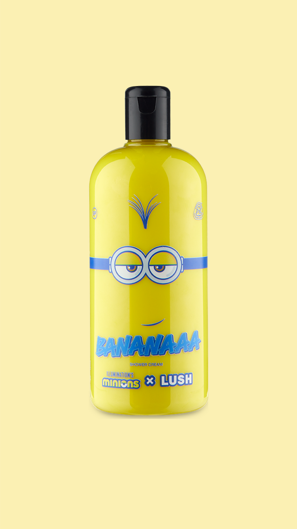 A classic LUSH shower gel bottle made with clear plastic. The bright yellow shower cream is visible through the bottle and there is a mischievous Minion face printed on the front.