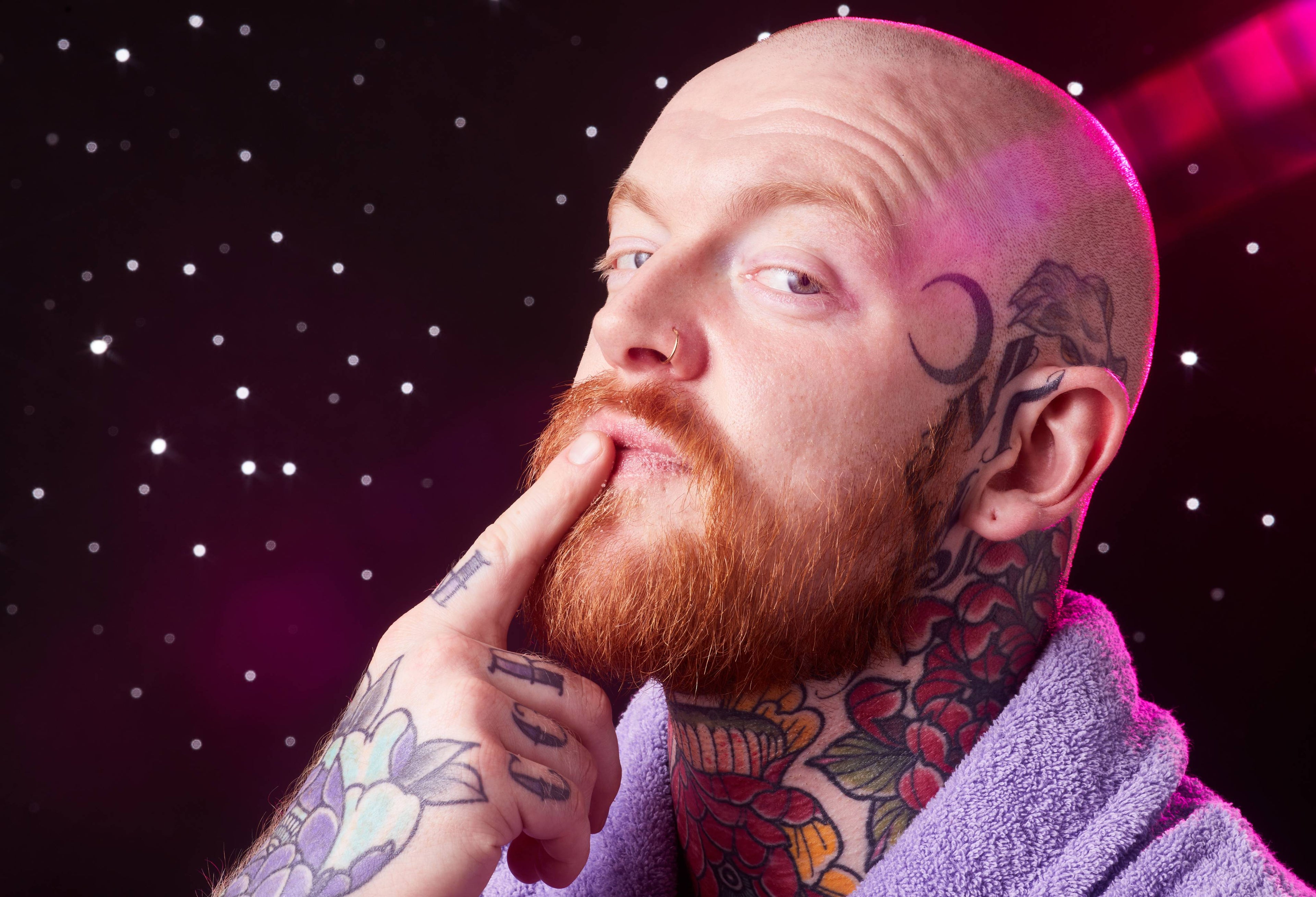 Image shows the model in front of a starry backdrop as they gently apply the Gingerbread lip scrub to their lips.