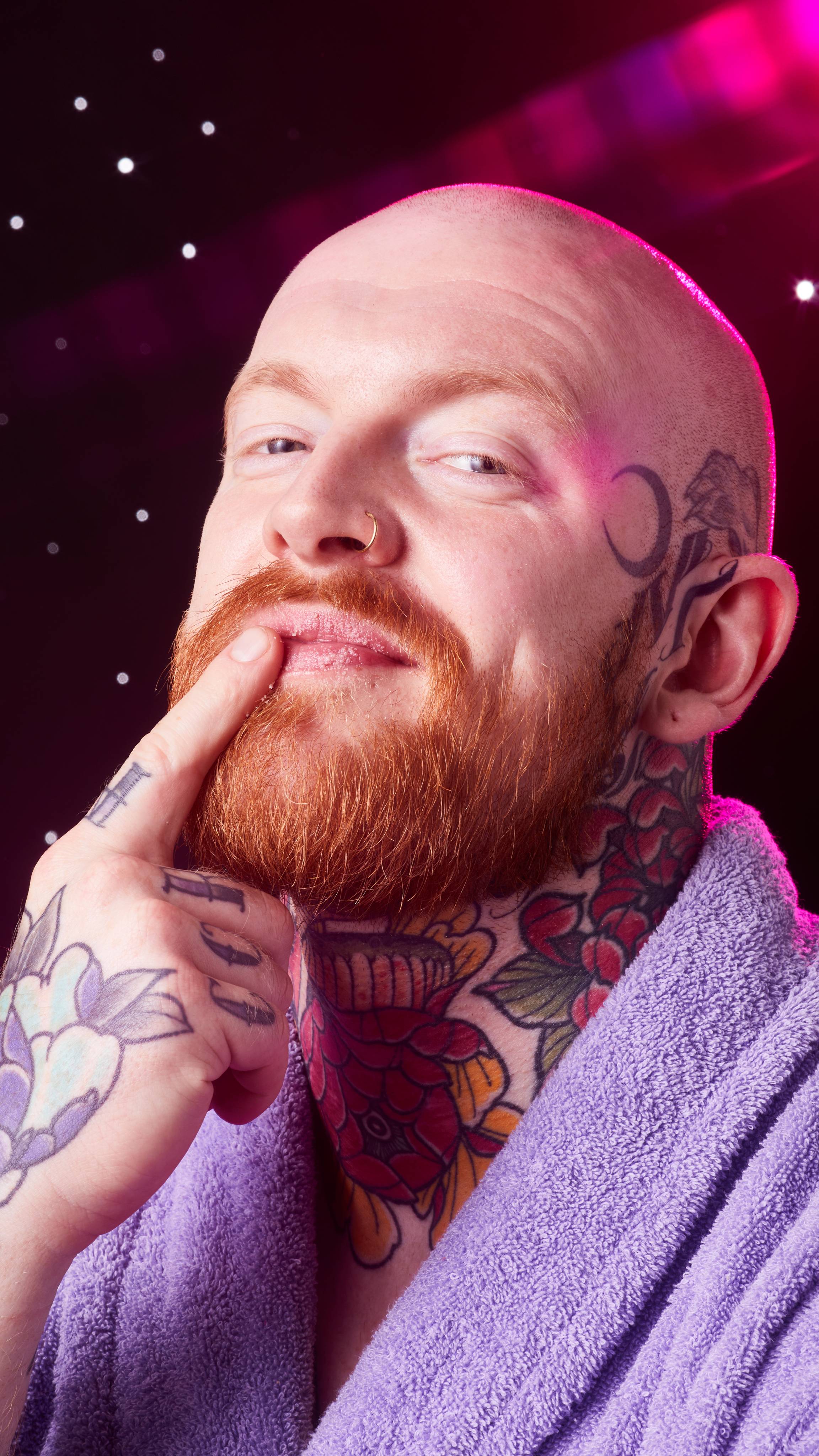 Image shows the model in front of a starry backdrop as they gently apply the Gingerbread lip scrub to their lips.