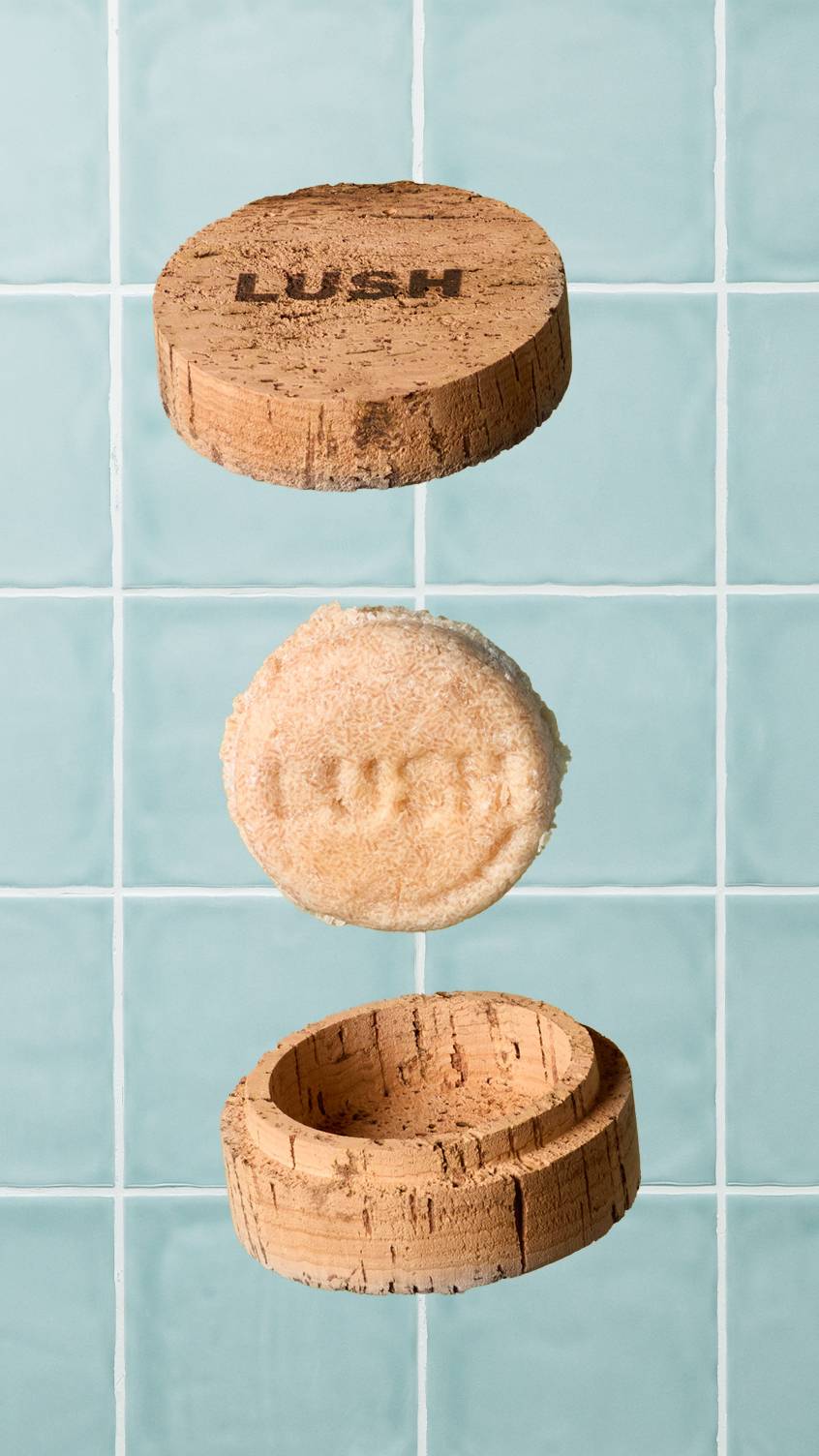 A textured beige Lush solid shampoo bar floats in the air between an open, round cork storage pot and its matching lid, which is branded with the "LUSH" logo. The background is made of light teal-blue square wall tiles.