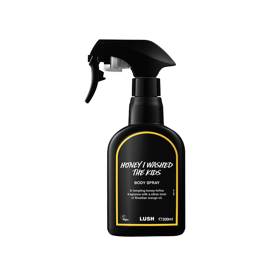 Honey I Washed The Kids body spray. A black spray bottle of Lush "Honey I Washed The Kids" Body Spray. The product label is black with a bright yellow banded border. White text states the product name and the scent description.