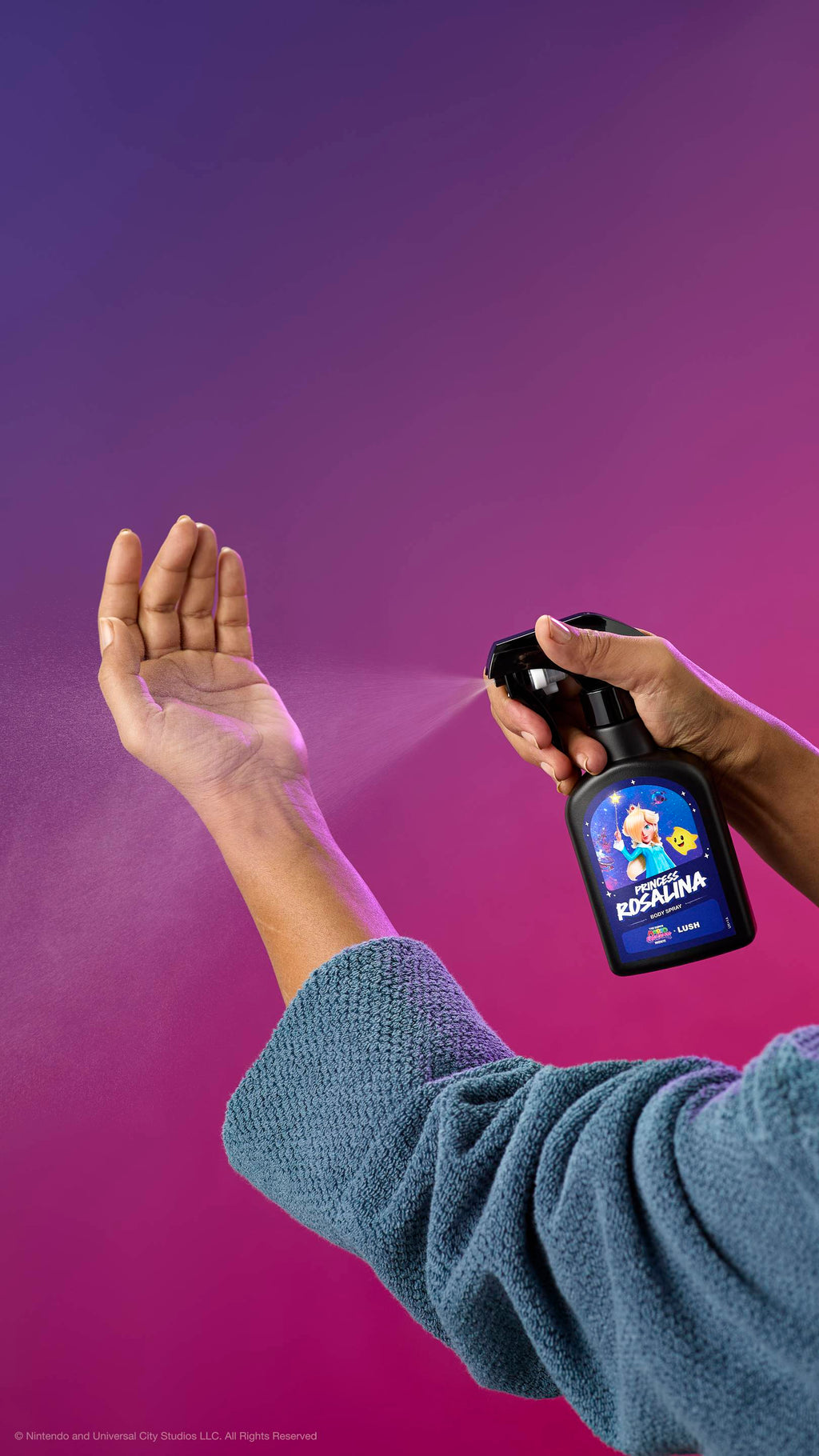 A person in a blue robe sprays Princess Rosalina body spray onto their inner wrist against a purple-pink gradient. The black bottle features a label with Princess Rosalina and a Luma.