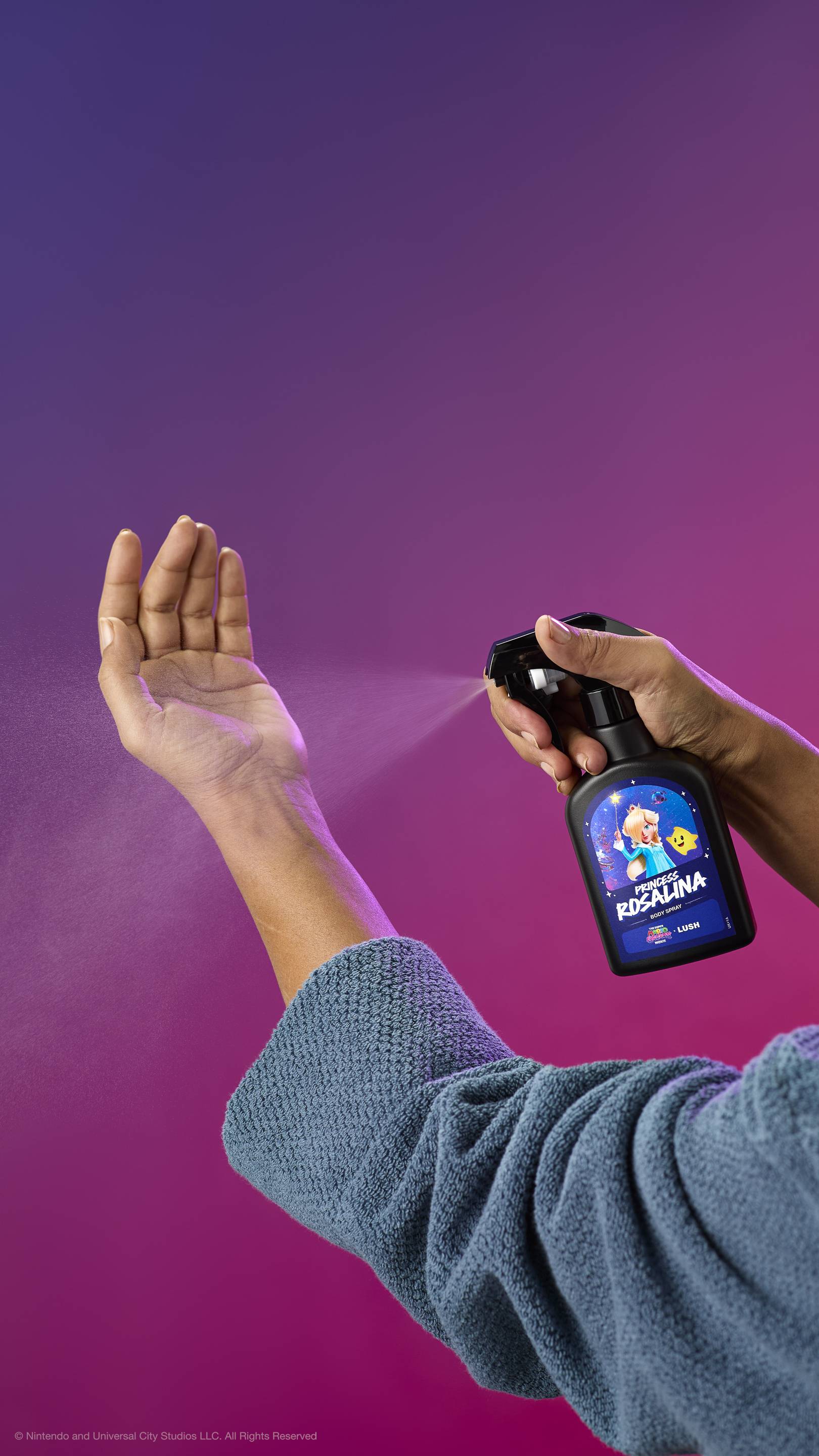A person in a blue robe sprays Princess Rosalina body spray onto their inner wrist against a purple-pink gradient. The black bottle features a label with Princess Rosalina and a Luma.