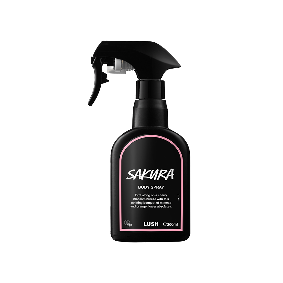 Sakura body spray. A black spray bottle of Lush "Sakura" Body Spray. The product label is black with a pastel-pink banded border. White text states the product name and the scent description.