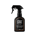 Sticky Dates body spray. A black spray bottle of Lush "Sticky Dates" Body Spray. The product label is black with a light brown banded border. White text states the product name and the scent description.