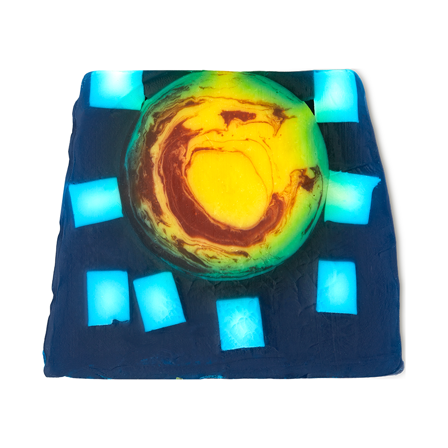 Alban Arthan. A colourful, thick soap slice with a deep, ocean-blue base with large square flecks of off-white. In the centre is a large, yellow circle with warm red swirls.