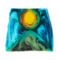 Alban Hefin is a thick, off-square slice of soap. An abstract design shows a green, pyramid-like shape at the bottom with a bright yellow, sun-like circle, surrounded by blue swirls.