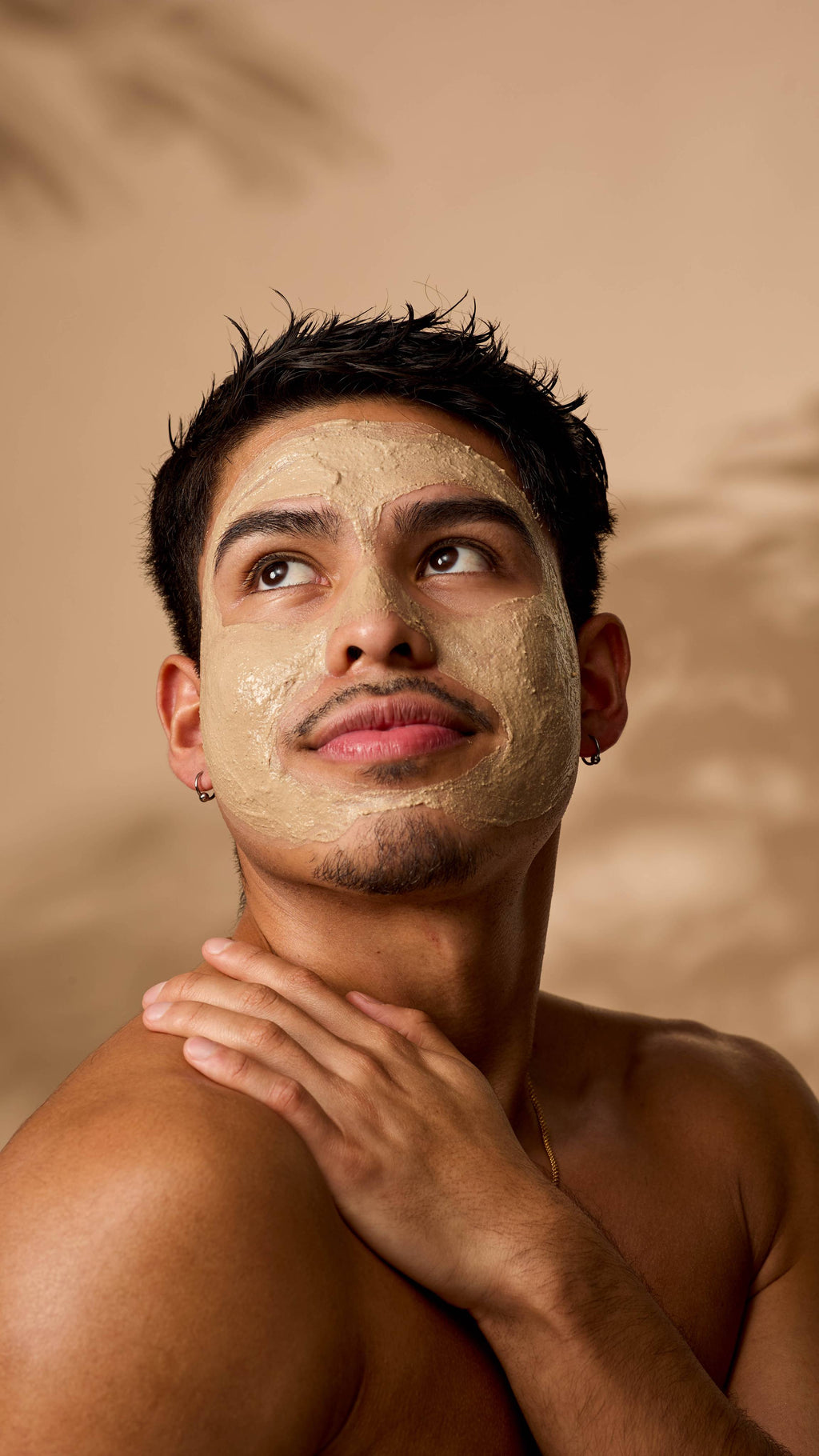 The image shows the model looking off into the distance as the Ayesha mask is applied evenly over their face.