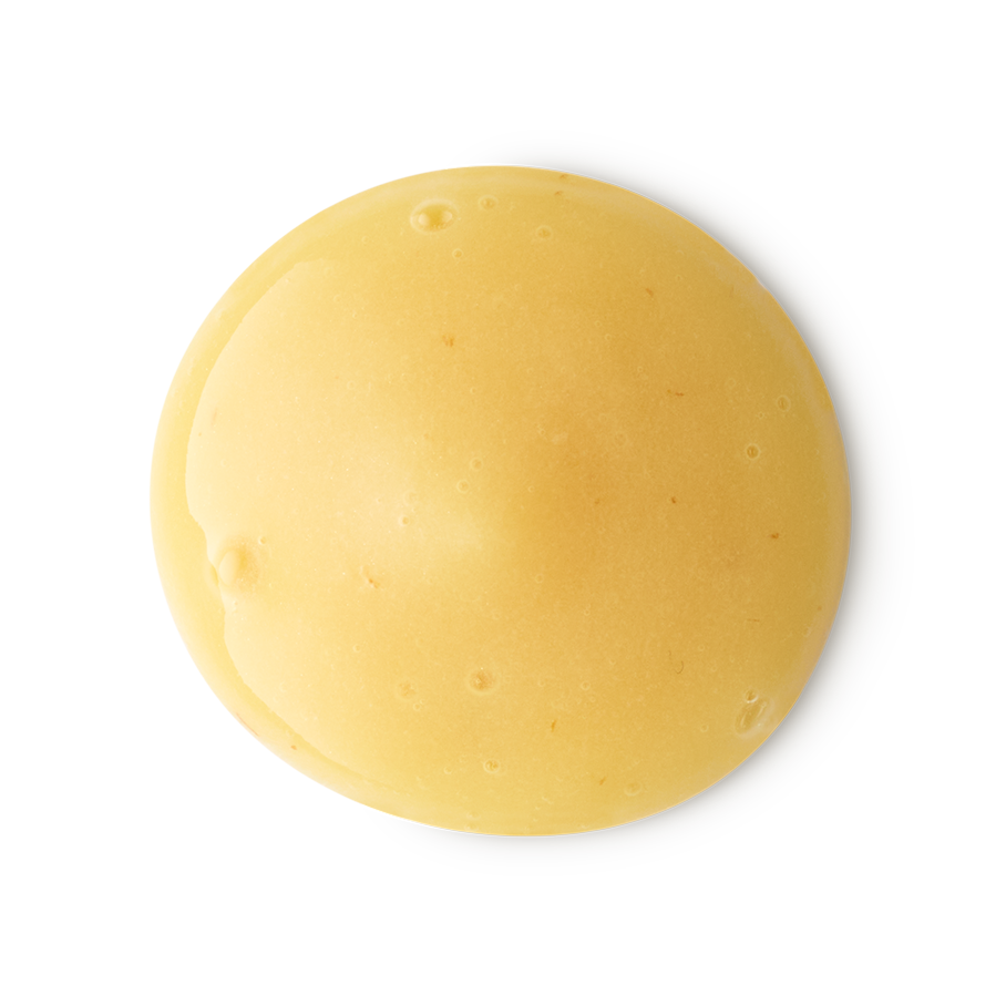 A smooth, circular dollop of creamy yellow shower gel with a glossy finish. The thick, opaque liquid features tiny air bubbles and is centered against a clean, neutral grey background.