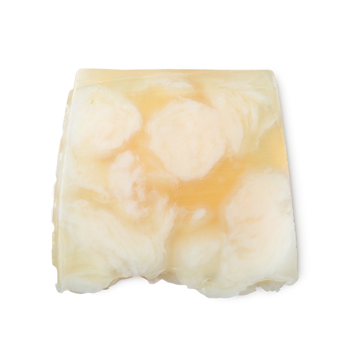 Bohemian. A light yellow, creamy swirled, smooth, trapezium shaped soap, with bumps along its left side.