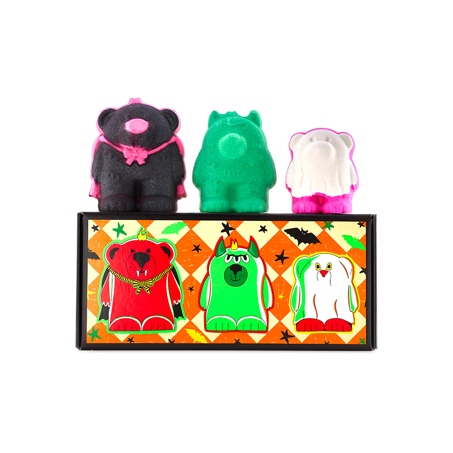 Boo Bears gift. Three monster bear bath bombs sit atop an orange chequered box featuring illustrations of themselves. Left to right: a black vampire bear, a green three-eyed monster bear, and a white ghost bear with bright pink feet.