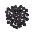 A pile of small, circular, black Boom! toothpaste tabs shot from above.