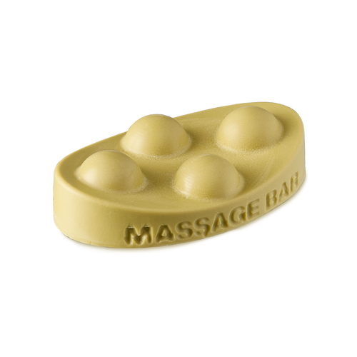 Brazilian Boom. An ivory-yellow, solid oil massage bar in an oval shape. The words "massage bar" are embossed on the side and there are four raised half-sphere, bubble-type shapes on top.