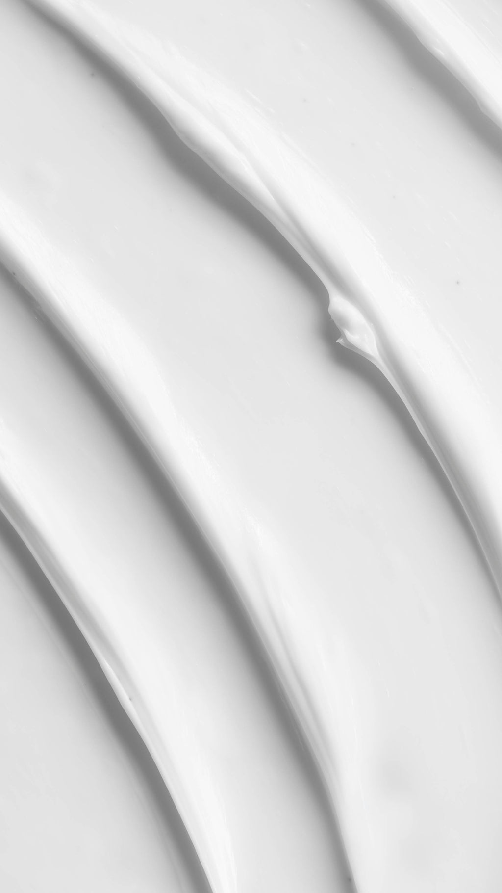 A close-up vertical shot of thick, creamy white product, likely the Celestial Moisturiser, showing several textured, undulating waves and ridges.