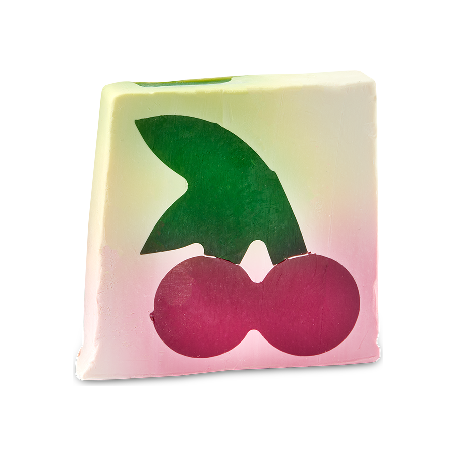 Cherry On Top. An off-square slice of cream-coloured soap which features a cross-section design of a large dark pink cherry with a large green leaf.