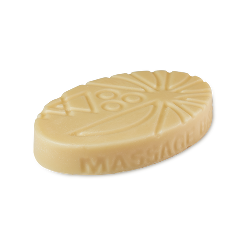 Coconut Drench. An oval, cream-coloured solid Lush massage bar with geometric and sunburst patterns embossed on top. The words 'MASSAGE BAR' are embossed along the curved side.