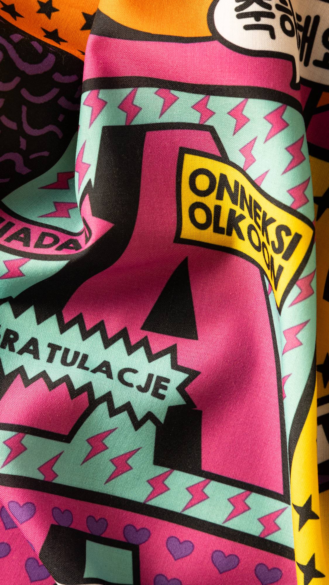 Image shows a super close-up of the Congratulations knot wrap. There is a large pink letter "A" surrounded by lightning bolts.