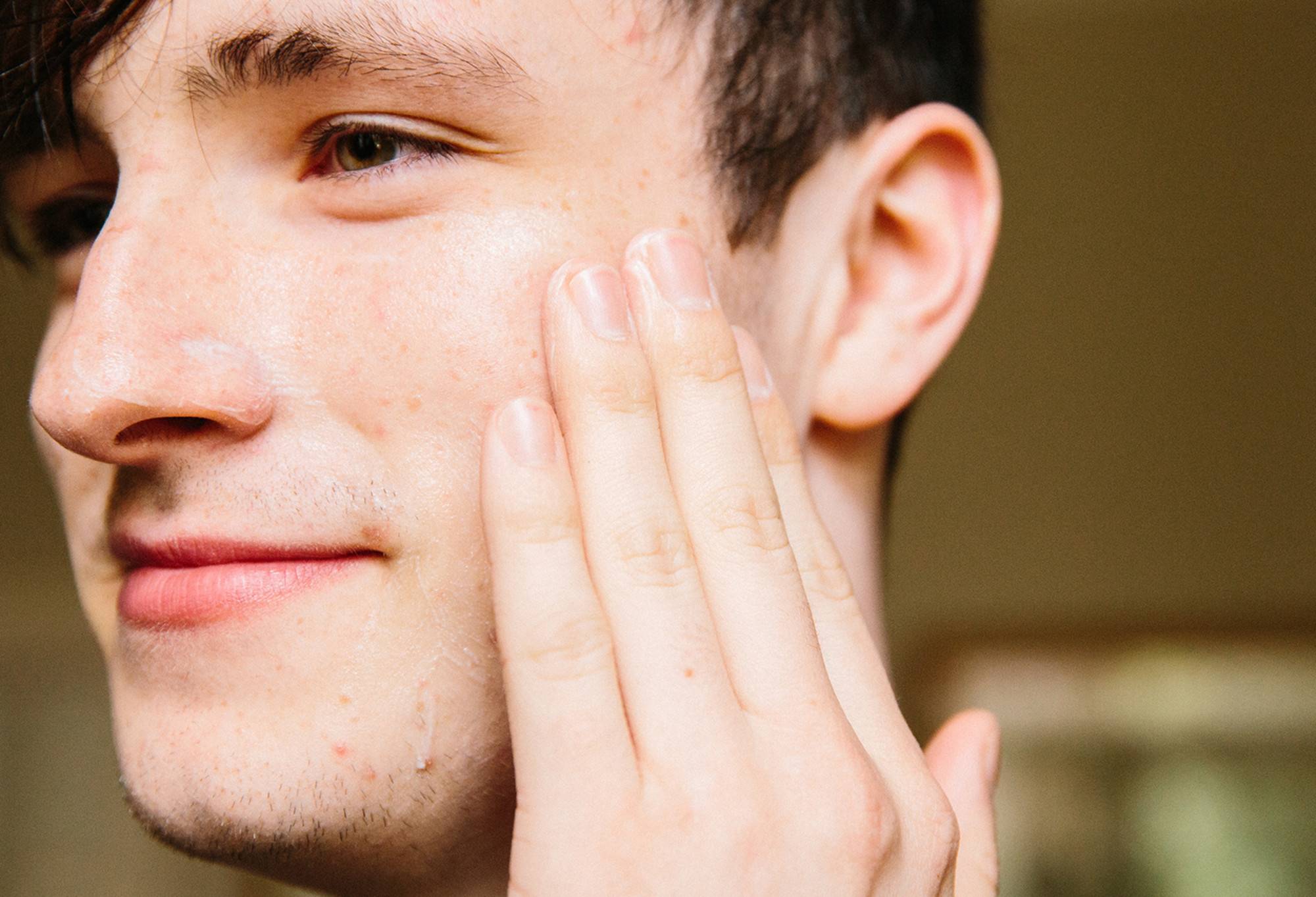 A light layer of smooth, orchid white Cosmetic Lad facial moisturiser is rubbed across one half of a smiling face.