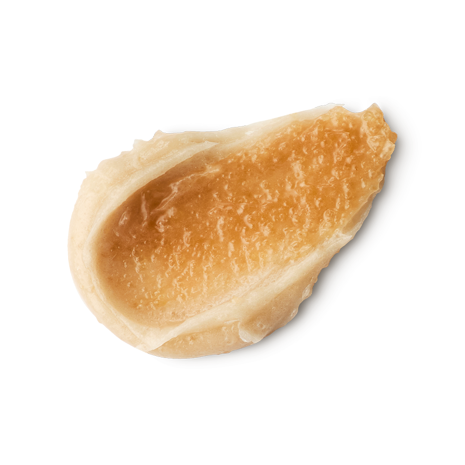 Crème Brûlée. A neatly smeared swatch of thick, ivory-coloured body scrub with a golden-brown textured topping product. The swatched cream has a glossy, slightly granular appearance with visible peaks and ridges.