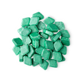 A pile of small, diamond-shaped, green Crème De Menthe mouthwash tabs shot from above.