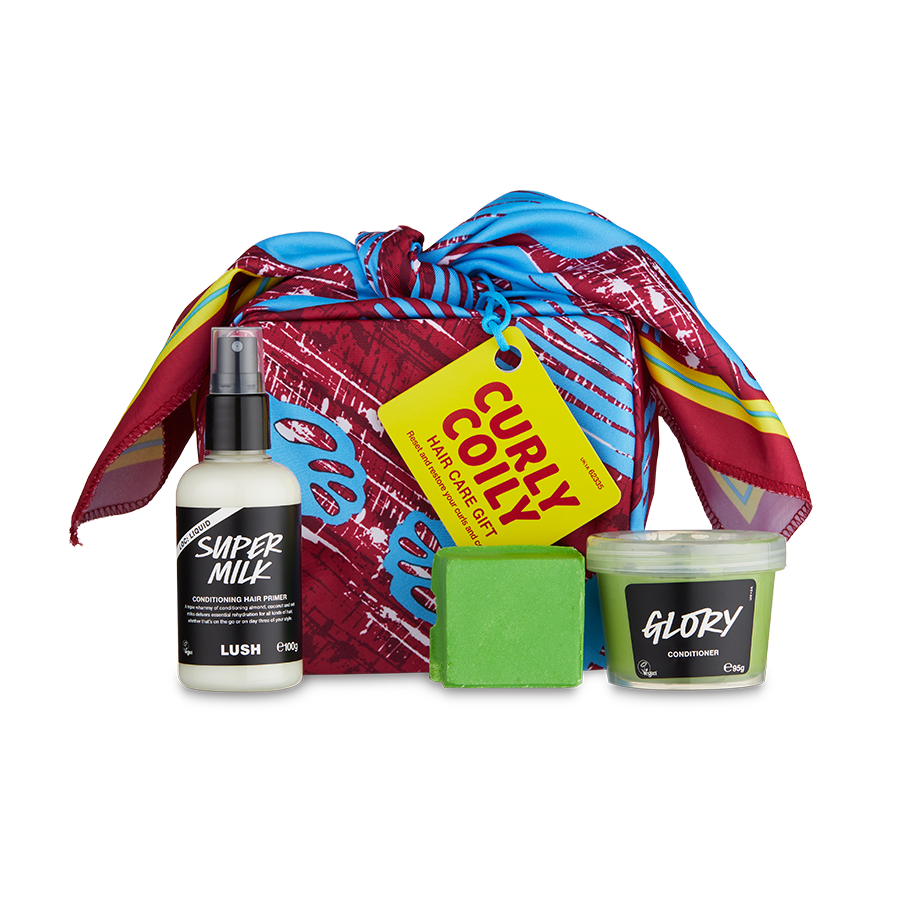 Curly Coily. A box is neatly wrapped in a colourful, exclusive knot wrap with three hair care products consisting of a spray bottle, co-wash and conditioner put beside.