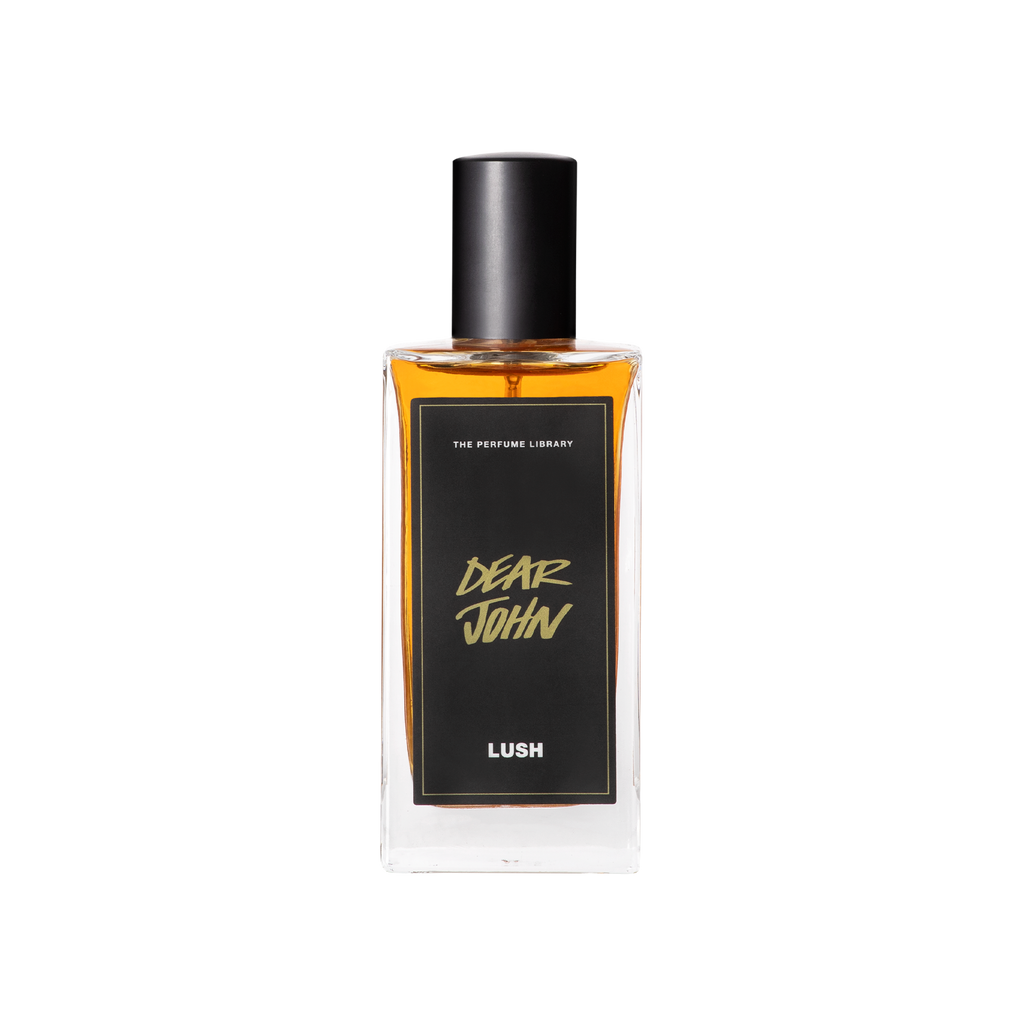 A glass perfume bottle filled with dark amber liquid. A black label reads 'The Perfume Library' and 'Dear John'.