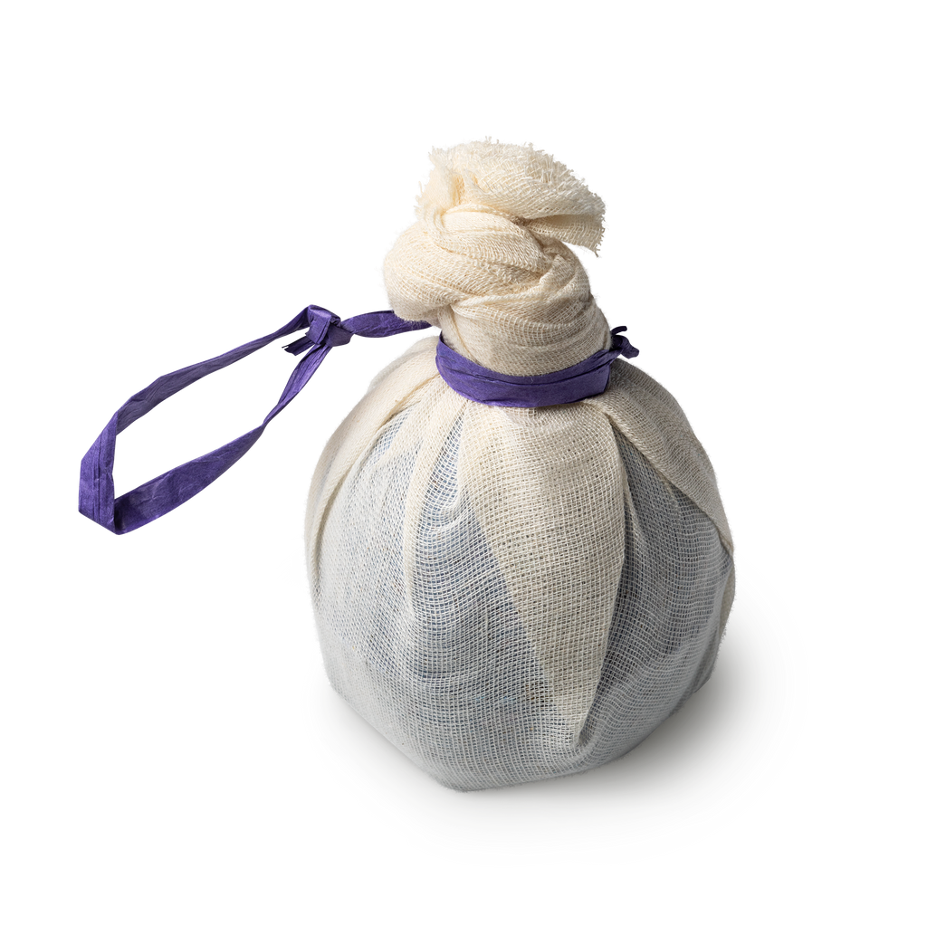 Deep Sleep. A round, purple bath bomb, beautifully wrapped in muslin tied in a knot and secured with a purple tie.