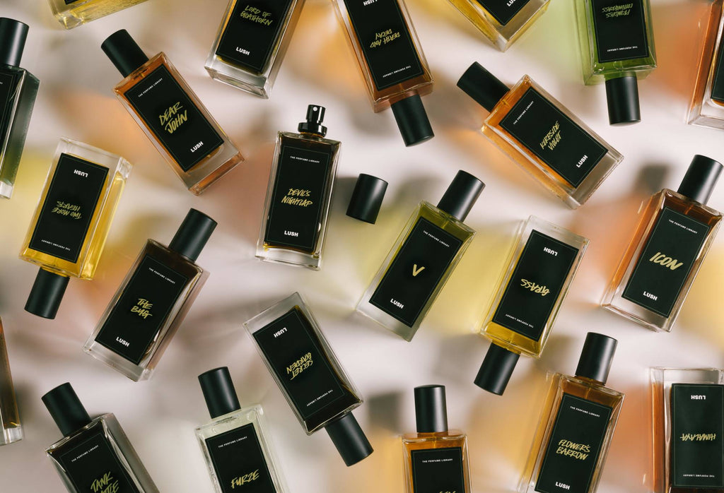 A number of black label perfume bottles are arranged randomly, with Devil's Nightcap in the centre, lid off, ready to spritz.