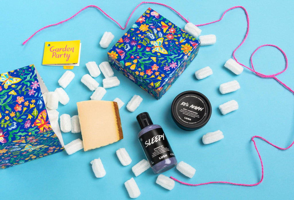 Garden Party, opened onto a light blue background, with its included products and eco packaging pops arranged randomly.