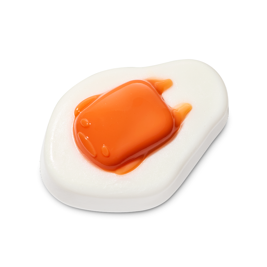 Gudetama. A glossy shower gummy shaped like an over-easy fried egg. It features a flat white base with a raised, translucent orange "yolk" in the centre that has the faint features of a lazy character face
