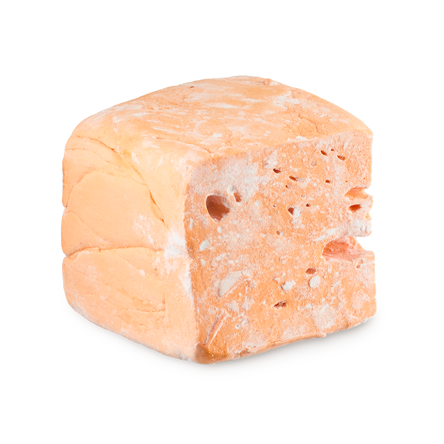 Passion Fruit Delight floating soap. A cuboid-shaped block of pastel orange soap, resembling the texture of a dense marshmallow, with a porous texture and visible holes. It has a light dusting of white powder.