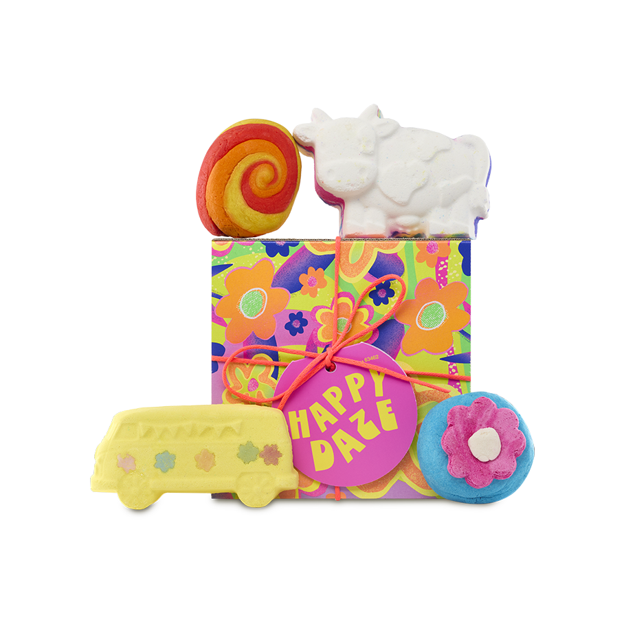 Happy Daze. A square gift box with a colourful neon flower design, tied with an orange string and a pink gift tag. Four bath products sit on top of and in front of the gift box.