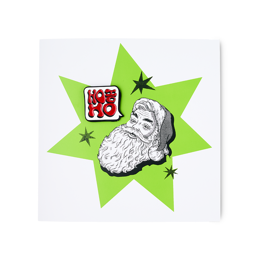 HO HO HO. A square greetings card with a white background. There is a central green star with an illustration of Santa's face. There is a removable enamel badge in the shape of a speech bubble which reads "Ho Ho Ho"