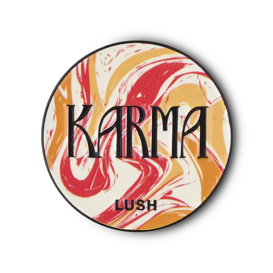 Karma pin badge. A circular metal pin features a swirled pattern of red, orange, and white marbled design. The word 'KARMA' is prominent in black letters, with 'LUSH' below it.