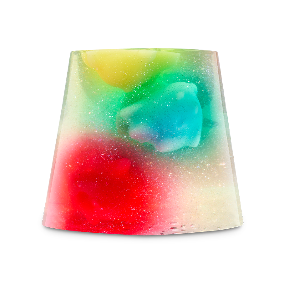 A translucent, trapezoidal-shaped shower jelly containing vibrant star-shaped Luma figures in yellow, green, blue, and red. The entire jelly is filled with shimmering plastic-free glitter