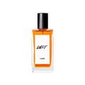 A glass perfume bottle filled with deep, reddish amber liquid. A white label reads 'Lust'.