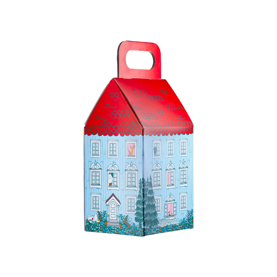 Moominhouse product holder. A house-shaped gift box designed to look like the blue Moomin house, featuring a scalloped red roof with a built-in carrying handle. Illustrated characters peek from windows.
