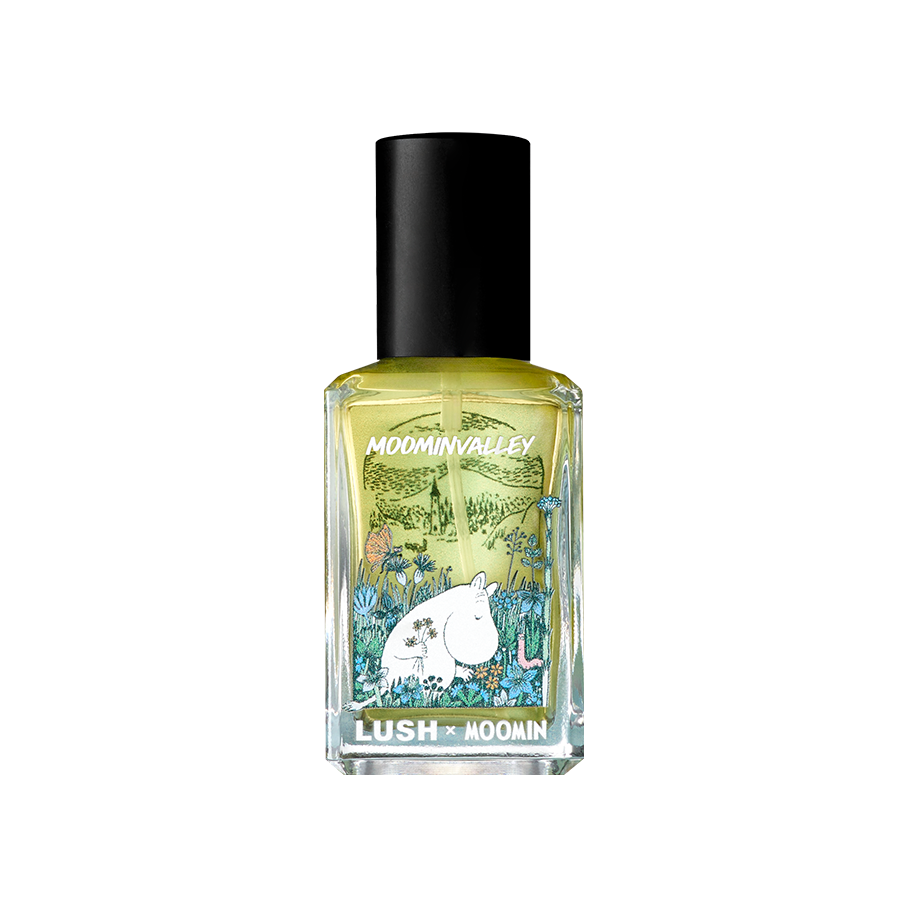 A rectangular glass bottle of pale perfume with a black cap. The clear, illustrated label reads "MOOMINVALLEY" and "LUSH x MOOMIN", featuring an illustration of Moomintroll holding flowers in a grassy field.