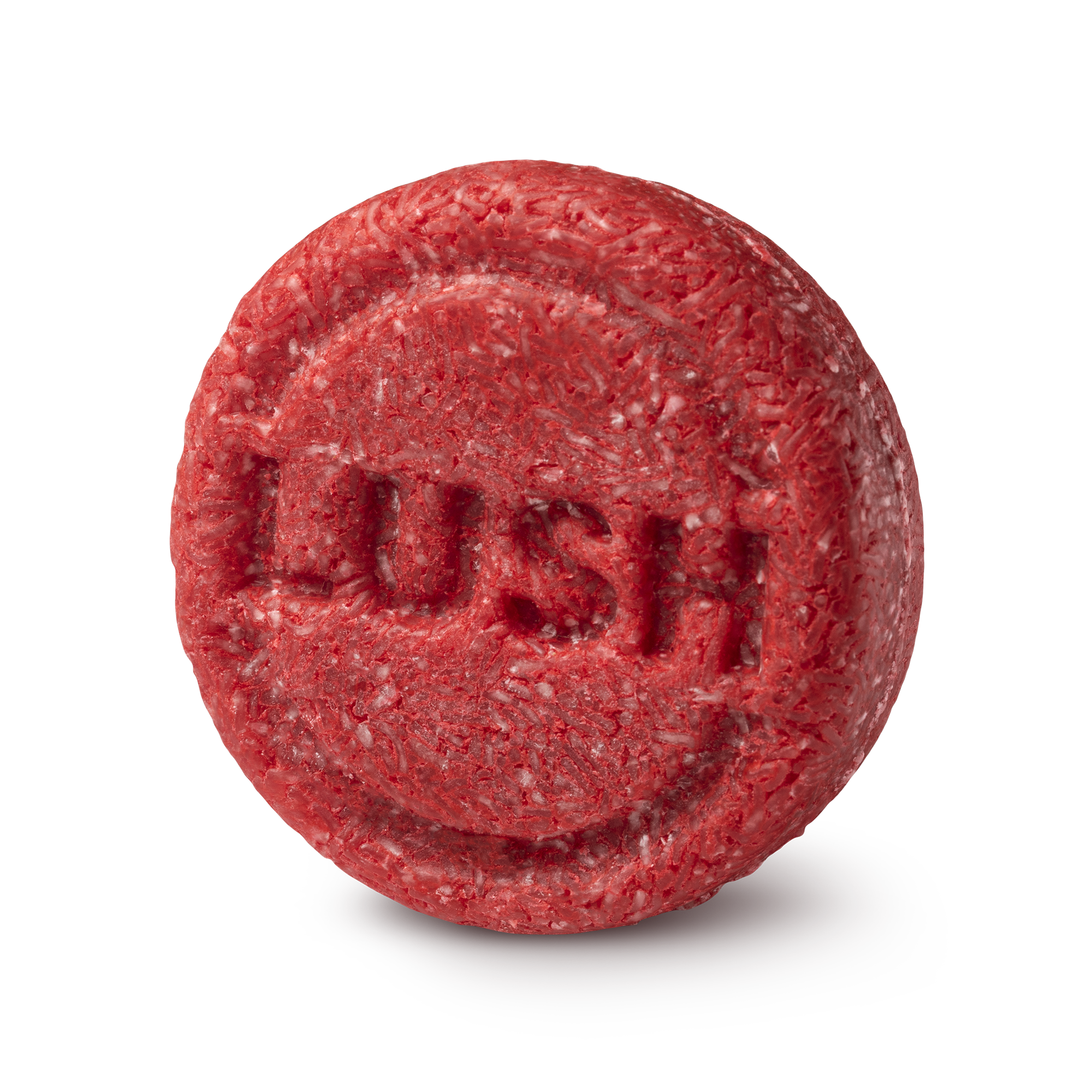 New shampoo. A circular, highly textured red solid shampoo bar. The fibrous, shredded surface features the brand name 'LUSH' embossed clearly in the centre of the round face.