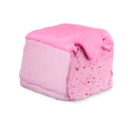 Happy Blooming Delight. A cuboid-shaped block of pastel pink soap, resembling the texture of a marshmallow. It is topped with a thick, glossy, darker pink coating that drips down one side, revealing a porous texture below.
