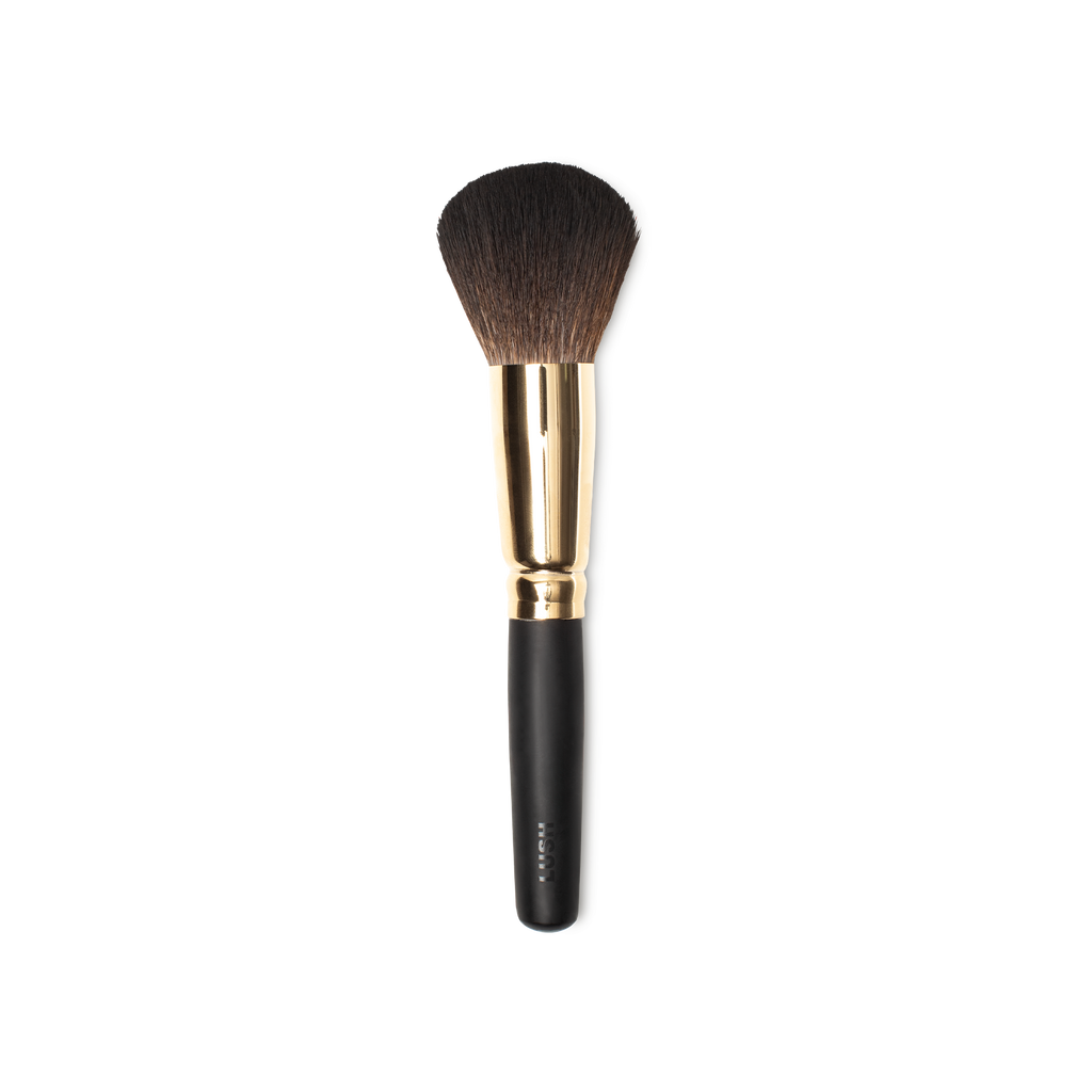 People Powder Brush. A large, dome-shaped powder brush, with tapered brown bristles and a gold and dark wooden handle.
