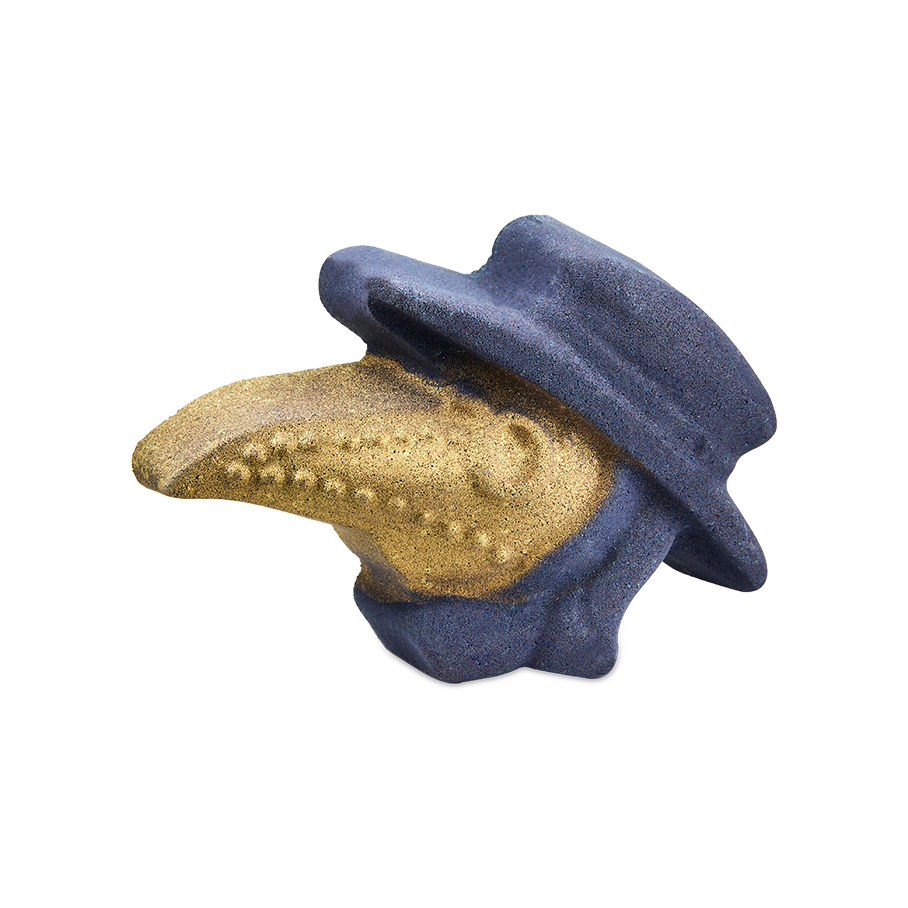 Plague Doctor. A bath bomb shaped like a plague doctor's head. The figure wears a dark purple brimmed hat and cowl, while the iconic long, beaked mask is covered in a glittering metallic gold finish.