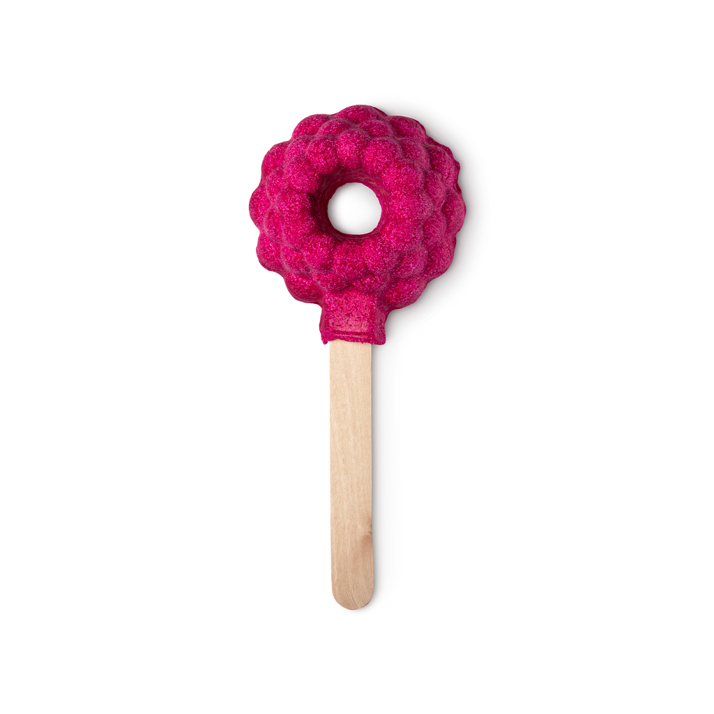 Raspberry Blower Bubble Bar. A red bumpy raspberry shape with a hole in the middle is mounted on a stick like an ice lolly.