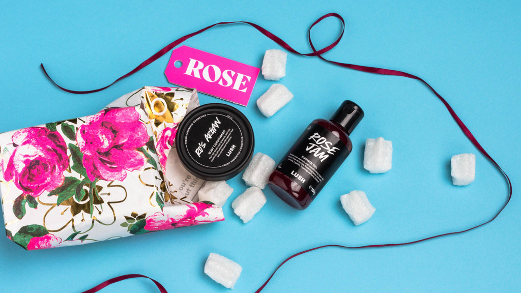 Rose, opened onto a light blue background, with its included products and eco packaging pops arranged randomly.